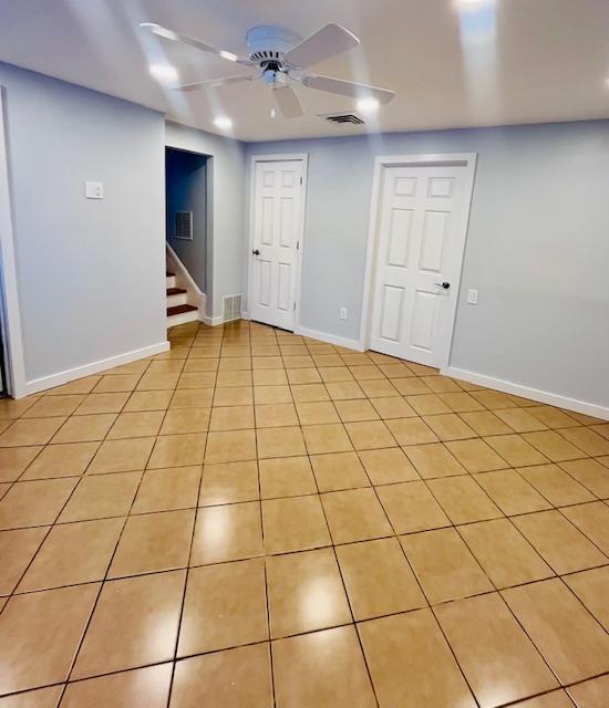 basement with light tile patterned flooring and ceiling fan