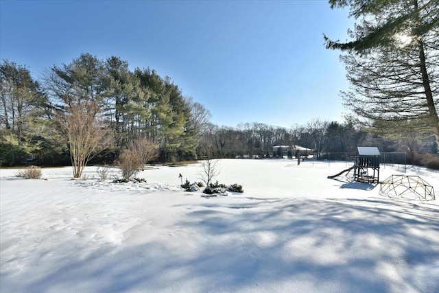 yard layered in snow featuring a playground