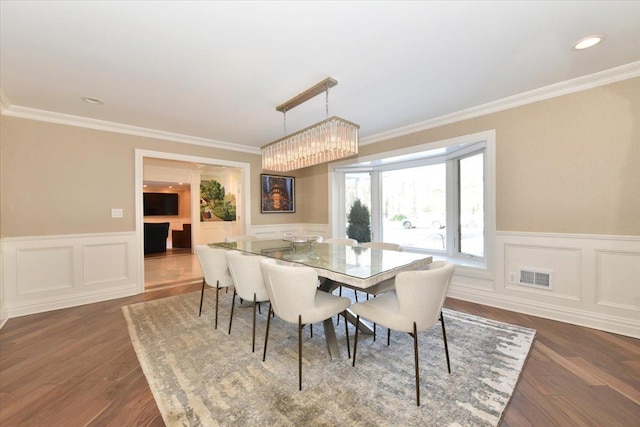 dining room with crown molding and dark wood-type flooring