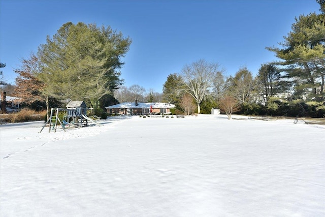 snowy yard featuring a playground