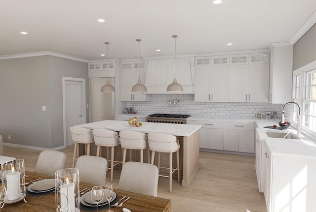 kitchen featuring light stone countertops, white cabinetry, a kitchen island, and backsplash