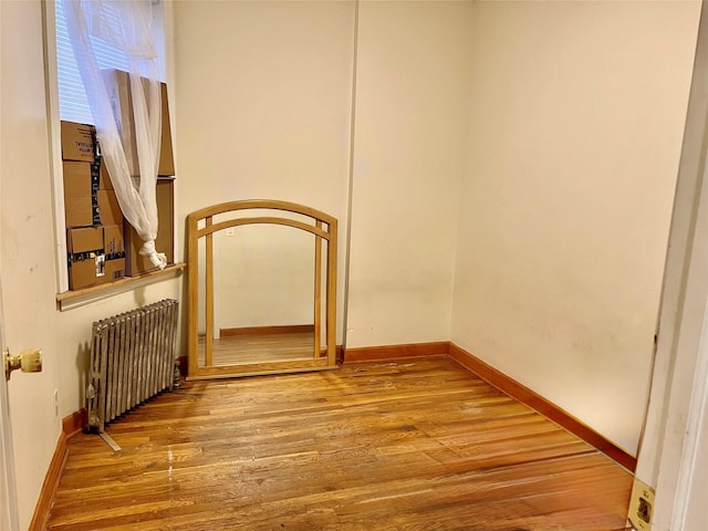 interior space with radiator heating unit and wood-type flooring