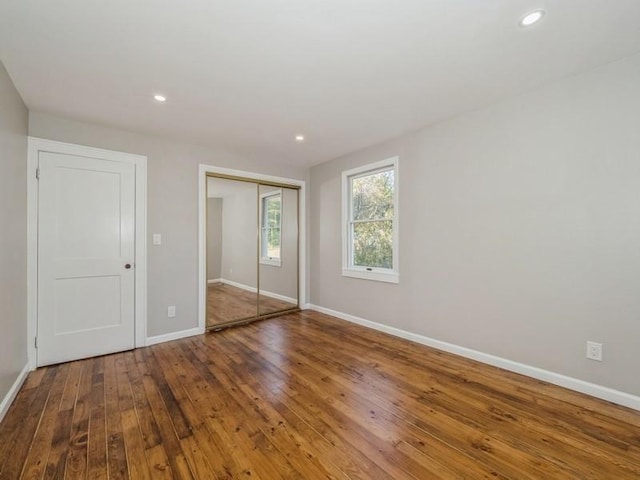 unfurnished bedroom featuring hardwood / wood-style flooring and a closet