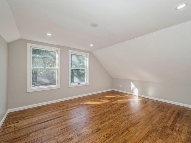 bonus room with vaulted ceiling and wood-type flooring