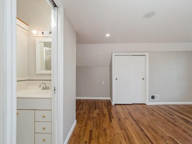 bonus room with hardwood / wood-style flooring and sink