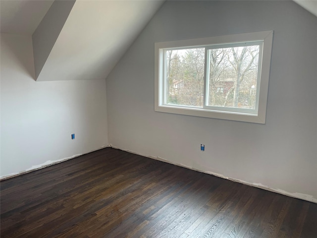 additional living space with dark wood-type flooring and lofted ceiling