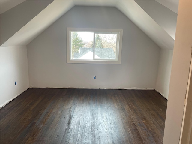 bonus room with dark wood-type flooring and vaulted ceiling