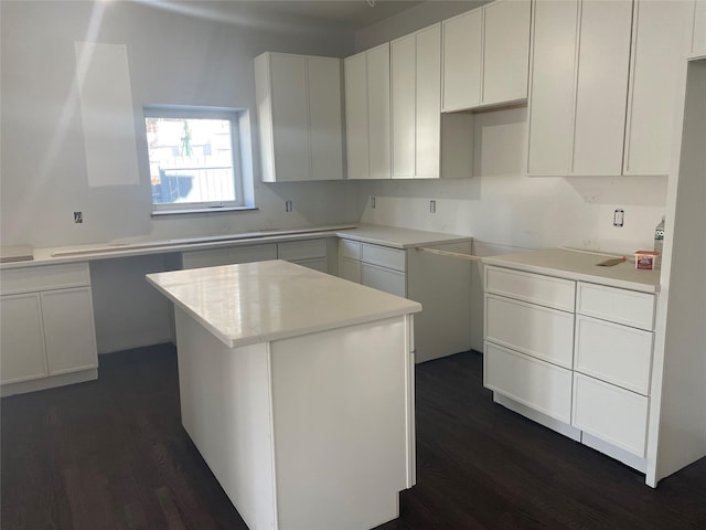 kitchen with white cabinetry, a kitchen island, and dark hardwood / wood-style floors