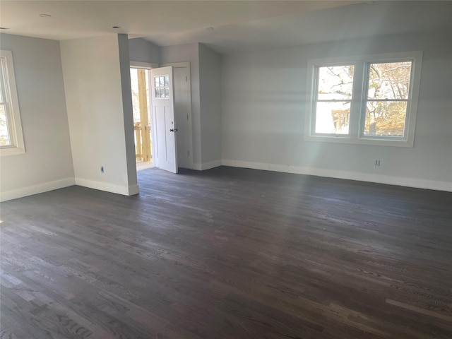 spare room with dark wood-type flooring and a wealth of natural light