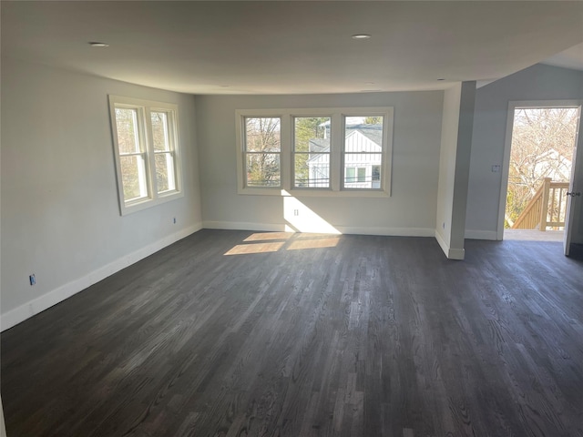 empty room with dark wood-type flooring and a healthy amount of sunlight