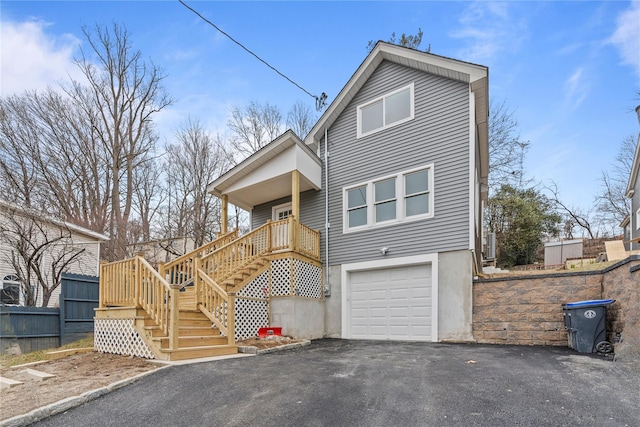 view of front of home featuring aphalt driveway, stairway, and a garage