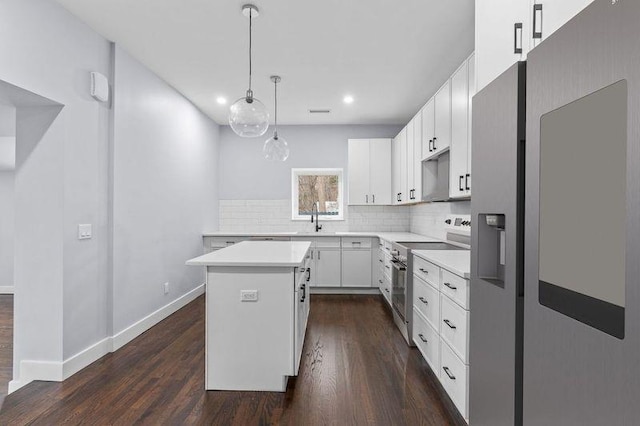 kitchen with a kitchen island, a sink, decorative backsplash, dark wood-type flooring, and appliances with stainless steel finishes