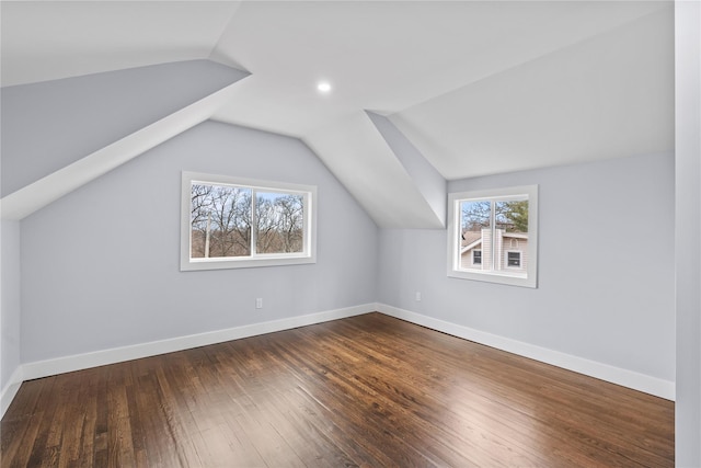 additional living space with vaulted ceiling, baseboards, and hardwood / wood-style flooring