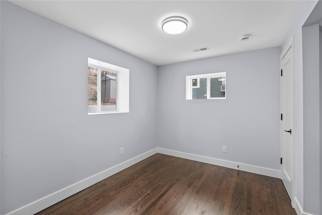 unfurnished bedroom with visible vents, baseboards, and dark wood-style floors