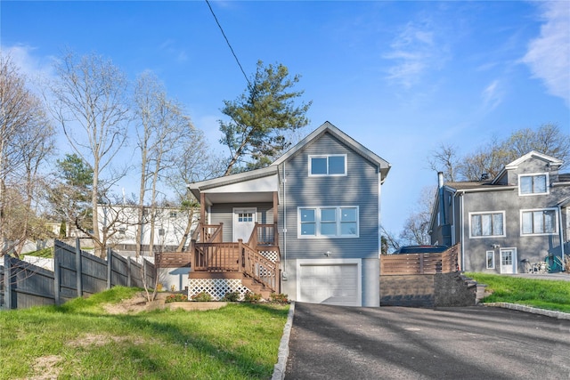view of front of home featuring an attached garage, stairway, fence, and driveway