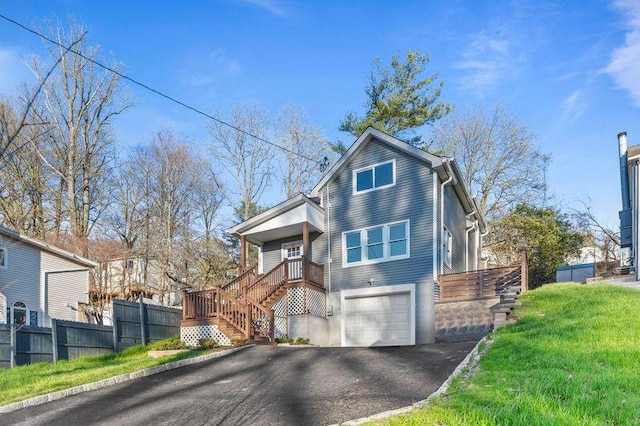 view of front of house with an attached garage, driveway, stairs, and fence