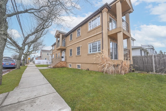 exterior space with a balcony and a yard