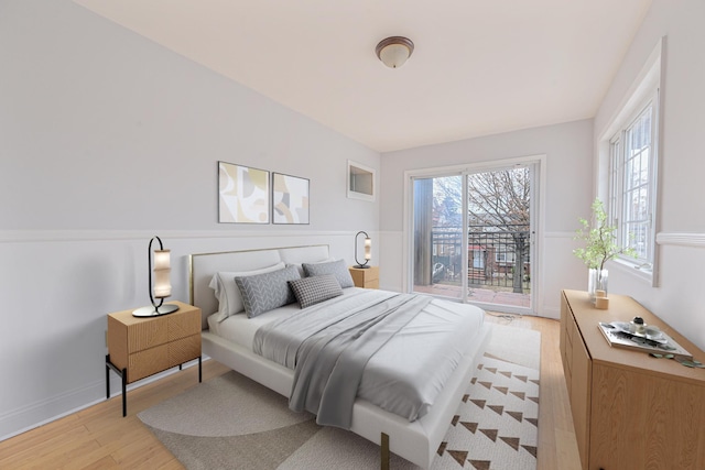 bedroom with access to exterior and light hardwood / wood-style floors