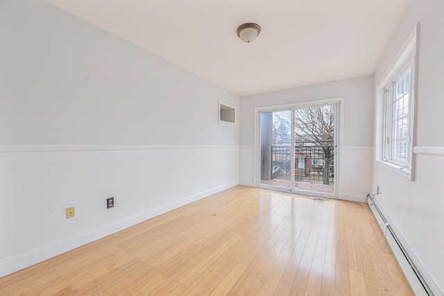 spare room with a baseboard radiator and light wood-type flooring