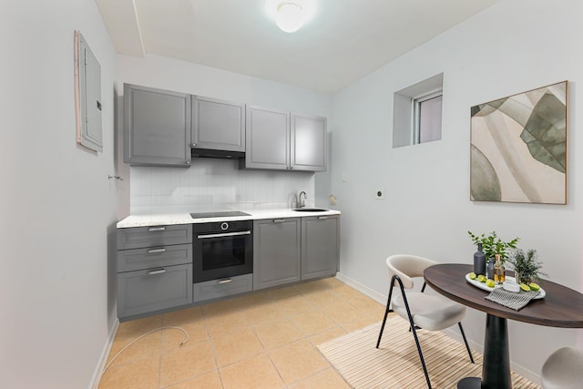 kitchen with wall oven, black electric stovetop, tasteful backsplash, and gray cabinetry