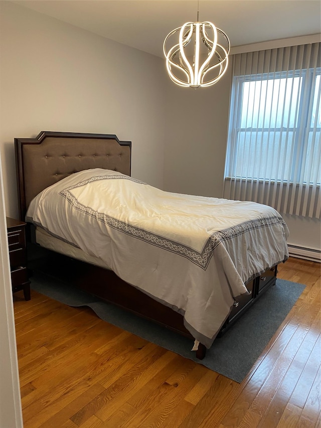 bedroom featuring wood-type flooring and a notable chandelier