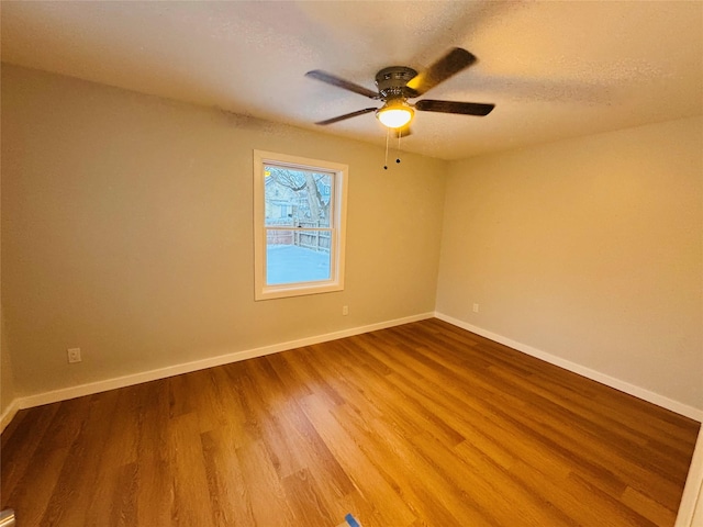 unfurnished room with ceiling fan, wood-type flooring, and a textured ceiling