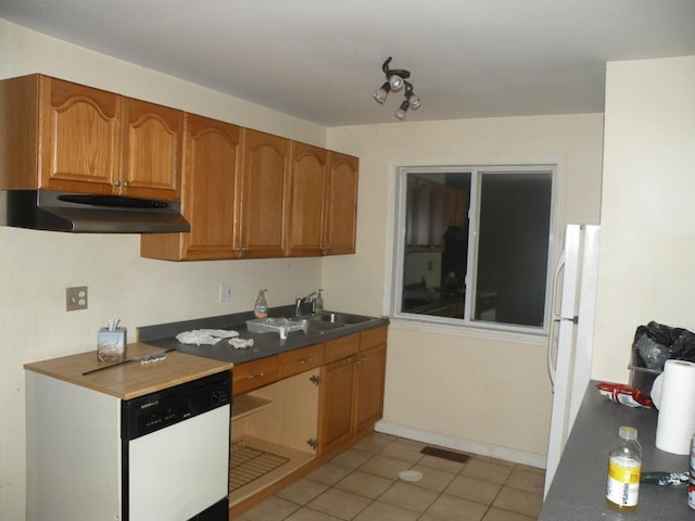 kitchen with light tile patterned flooring, white appliances, and sink