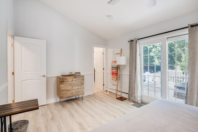 bedroom with access to exterior, vaulted ceiling, baseboard heating, and light wood-type flooring