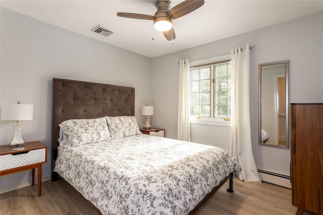 bedroom featuring wood-type flooring, ceiling fan, and baseboard heating