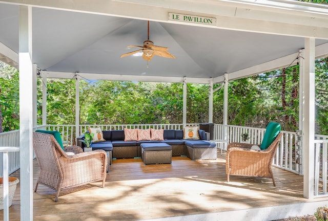 wooden deck with an outdoor hangout area and ceiling fan