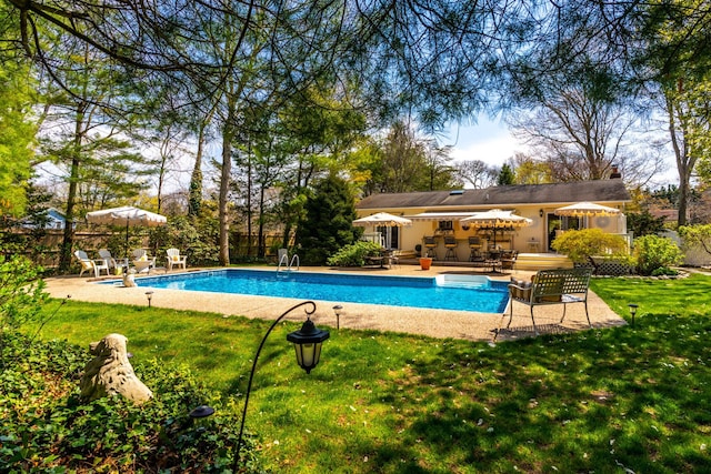 view of swimming pool with a patio and a yard