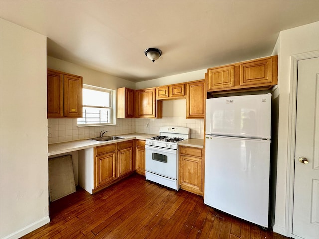 kitchen featuring tasteful backsplash, dark hardwood / wood-style flooring, sink, and white appliances