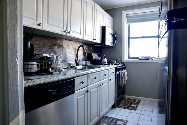 kitchen featuring sink, white cabinetry, backsplash, stainless steel appliances, and light tile patterned flooring