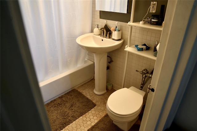 bathroom featuring toilet, tile walls, shower / tub combo, and decorative backsplash