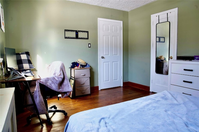 bedroom featuring dark wood-type flooring and a textured ceiling