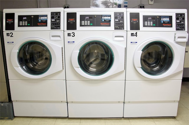 laundry area with separate washer and dryer and light tile patterned floors