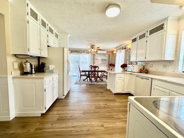 kitchen with white cabinetry, a textured ceiling, dishwasher, kitchen peninsula, and light hardwood / wood-style floors