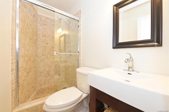 bathroom with walk in shower, vanity, and toilet