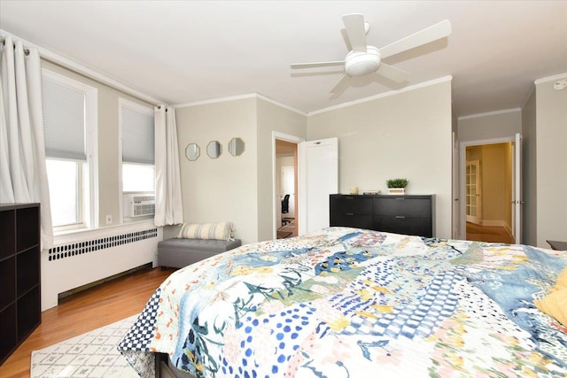 bedroom with crown molding, radiator heating unit, ceiling fan, and light hardwood / wood-style floors