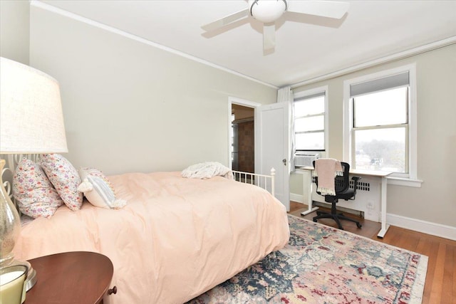 bedroom with ornamental molding, hardwood / wood-style floors, ceiling fan, and cooling unit