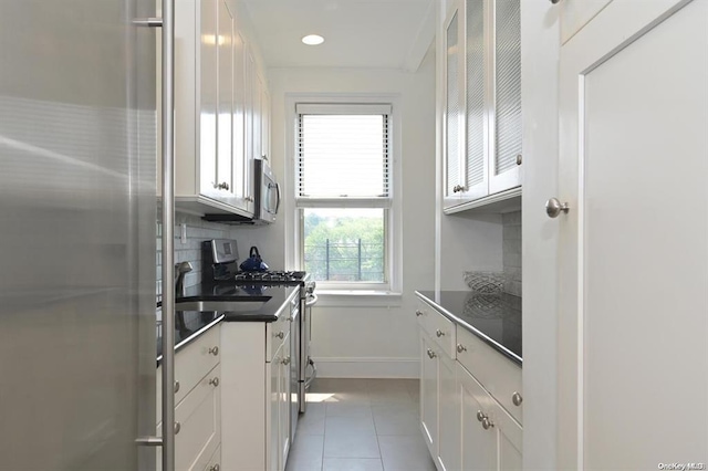 8 Barstow Rd Unit 7-E, Great Neck, NY 11021 - kitchen featuring stainless steel appliances, light tile patterned floors, white cabinetry, dark countertops, and recessed lighting