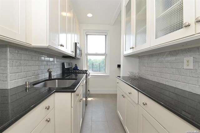8 Barstow Rd Unit 7-E, Great Neck, NY 11021 - kitchen with stainless steel appliances, a sink, baseboards, and white cabinetry