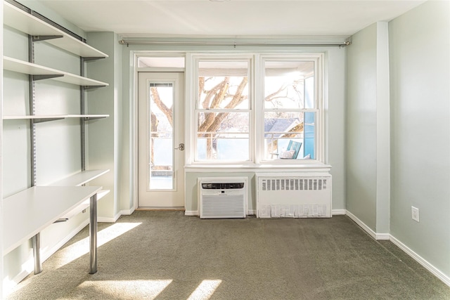 doorway to outside featuring carpet, radiator heating unit, baseboards, and a wall mounted AC