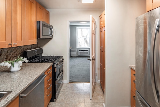 kitchen featuring light stone counters, light colored carpet, backsplash, appliances with stainless steel finishes, and cooling unit