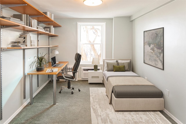 carpeted bedroom featuring baseboards and an AC wall unit