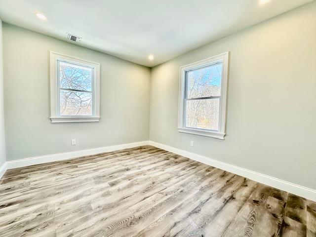 empty room with a healthy amount of sunlight and light wood-type flooring