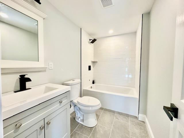 full bathroom featuring tiled shower / bath, vanity, tile patterned floors, and toilet