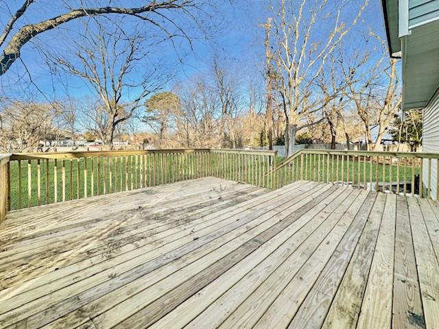 wooden terrace with a lawn