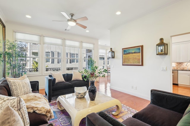 living room with ornamental molding, a wealth of natural light, ceiling fan, and light wood-type flooring