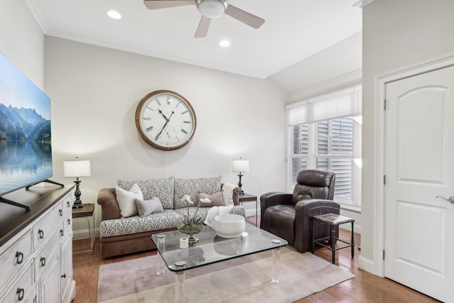 living room with crown molding, ceiling fan, lofted ceiling, and light wood-type flooring